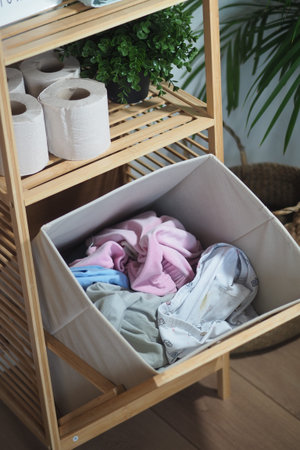 Laundry basket filled with colorful clothes in a cozy room