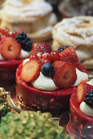 Delicious berry desserts on a display table at a bakeryの写真素材