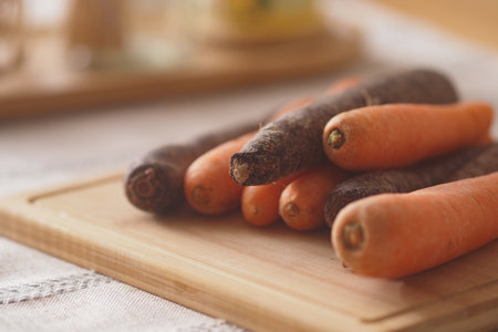 Colorful carrots on a cutting board in the kitchenの写真素材