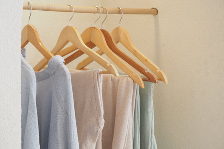Soft clothing hanging on wooden hangers in a closetの写真素材