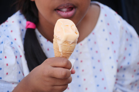 Child enjoying ice cream on a warm sunny dayの写真素材