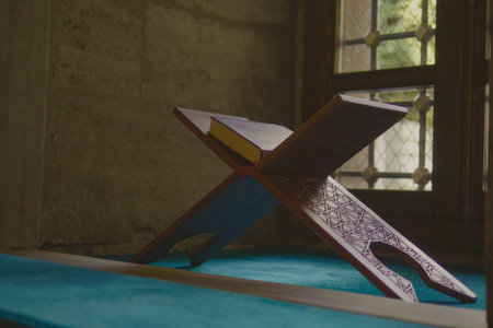 Quran placed on ornate stand near window with natural lightの写真素材