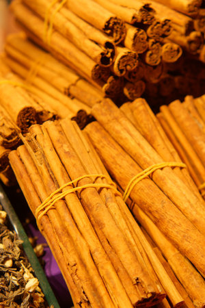 Stacked cinnamon sticks at a market in the evening lightの写真素材