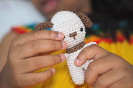 Child holding a handmade crochet dog toy in bright colors