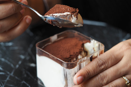 Someone is savoring a delicious dessert with rich chocolate and creamの写真素材