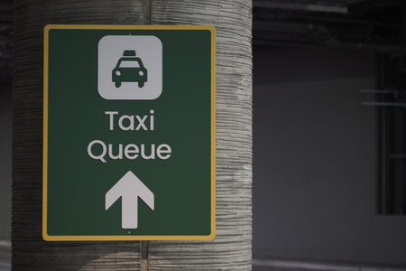 Taxi queue sign guides passengers at busy airport locationの写真素材