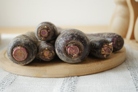 Fresh black carrots on a wooden cutting boardの写真素材