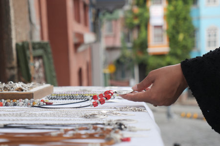 Hand selecting jewelry at a market in a colorful townの写真素材