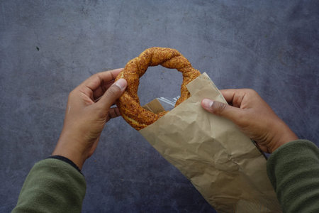 Freshly baked pastry held in hands at a food market