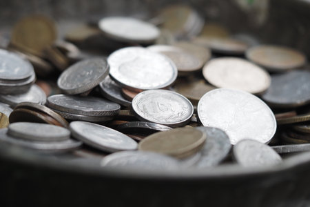 Collection of various coins in a metal bowlの写真素材