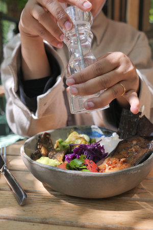 Delicious meal being seasoned at a cozy outdoor cafeの写真素材