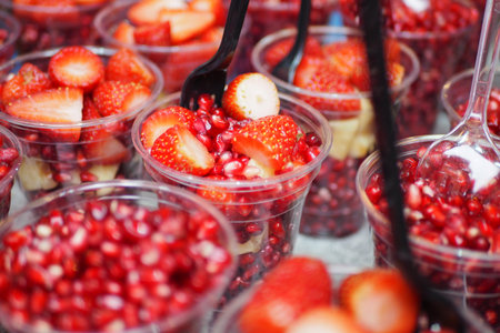 Fresh fruit cups with strawberries and pomegranate seedsの写真素材