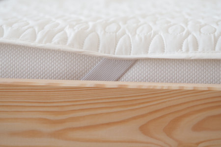 Soft mattress on wooden bed frame showcasing cozy designの写真素材