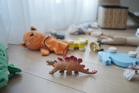 Colorful toys scattered on wooden floor in a playroomの写真素材