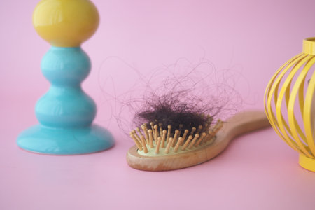 hair fall concept with hairbrush holds fallen hairの写真素材