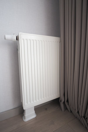 Radiator placed in corner near curtain in a modern roomの写真素材
