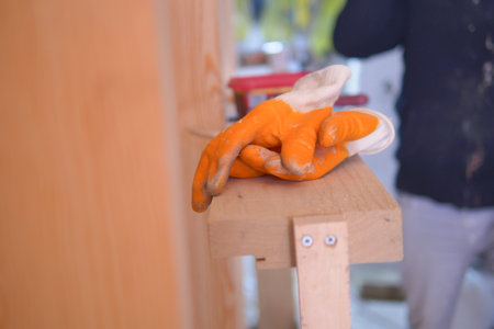 Worker gloves resting on wooden shelf in workshopの写真素材