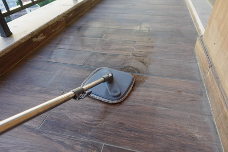 Sweeping the balcony for a clean living spaceの写真素材