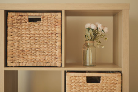 Decorative shelving unit with woven baskets and flowersの写真素材