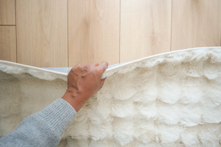 Hand lifting a soft rug off a wooden floorの写真素材