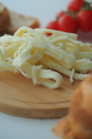 Freshly shredded cheese on a wooden cutting boardの写真素材