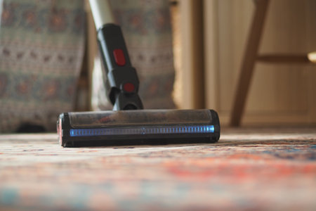Cleaning carpet with a vacuum cleaner indoorsの写真素材