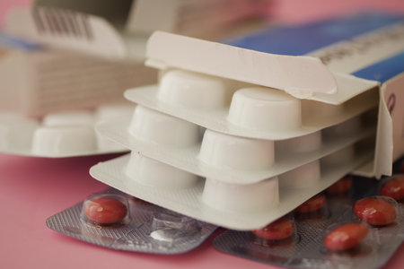 Medication packages displayed on a pink surfaceの写真素材