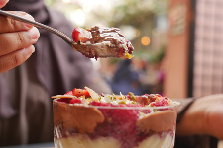 Spoonful of dessert enjoying flavors in an outdoor settingの写真素材