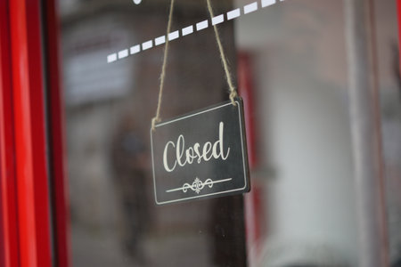 Closed sign hanging on a cafe door during business hoursの写真素材