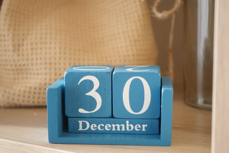Wooden calendar displaying December 30 date on a shelfの写真素材