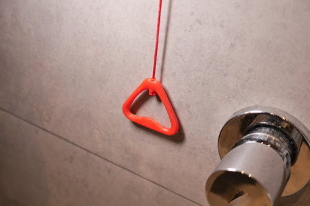 Red triangular handle hanging near bathroom faucetの写真素材