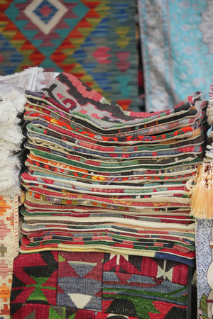 Colorful stacked textiles in a vibrant market displayの写真素材