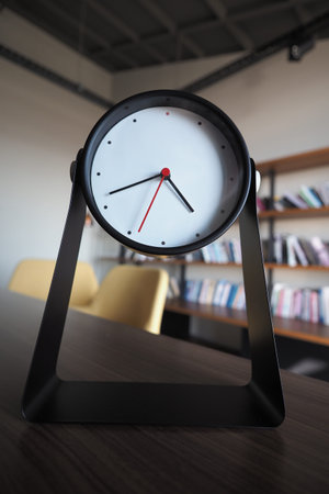 Modern clock on desk in a minimalist workspace setup