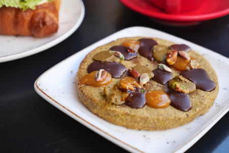 A cookie topped with nuts and chocolate on a table