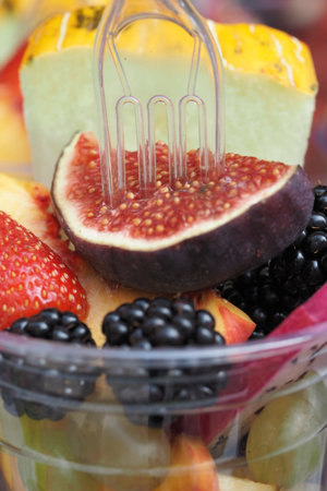 Colorful assortment of fresh fruits in a clear cupの写真素材