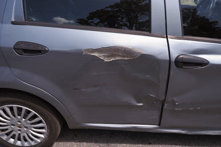 Car damage shows significant scratches and dents on sideの写真素材
