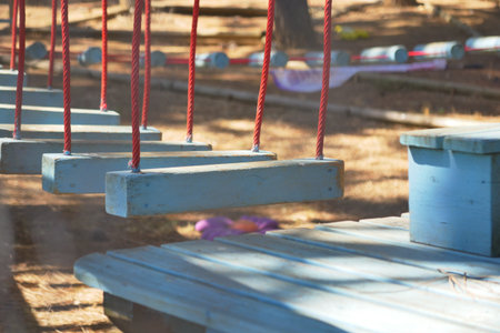 Swings hanging in a sunny outdoor playground settingの写真素材