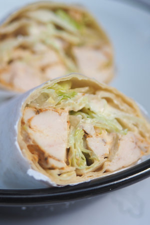 Delicious chicken wrap with fresh lettuce and sauceの写真素材