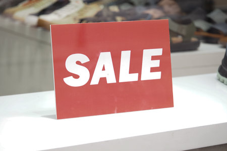 Store displays sale sign in window for customersの写真素材