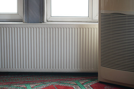 Heating unit next to window in indoor space during daytimeの写真素材