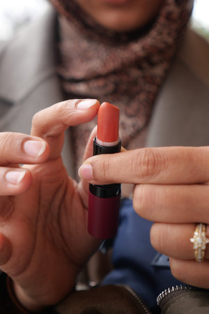 Woman holds lipstick outdoors near the cityの写真素材