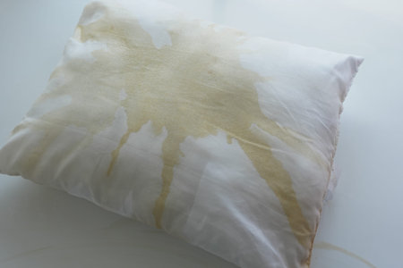Pillow with yellow stain on a white backgroundの写真素材