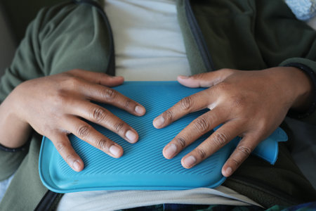 Resting person with blue heating pad on chestの写真素材