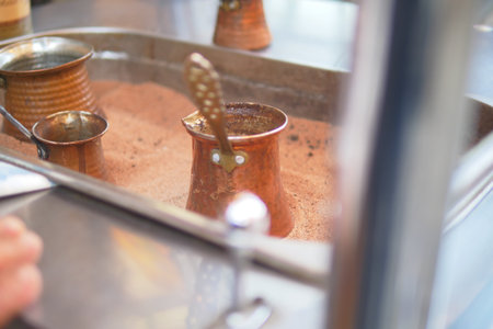 Brewing turkish coffee with copper pots in a busy kitchenの写真素材