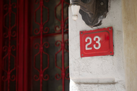 Number 23 displayed on a wall near a red gateの写真素材