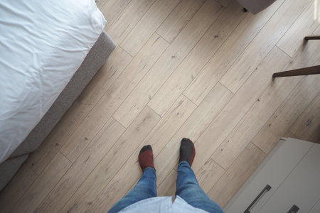 Feet on wooden floor in a room with simple furnitureの写真素材
