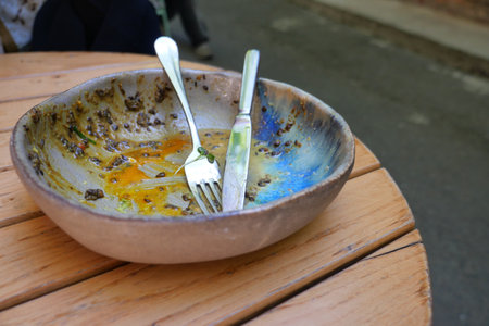 Empty plate sits on wooden table in outdoor settingの写真素材