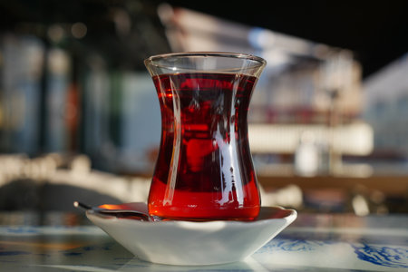 Warm Turkish tea in a glass on a table outsideの写真素材