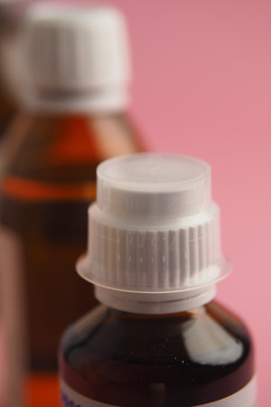 Close-up view of medicine bottles on pink backgroundの写真素材