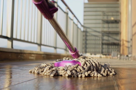 Mop cleaning floor on balcony of a tall buildingの写真素材